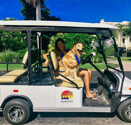 woman and dog in a sanibel cart